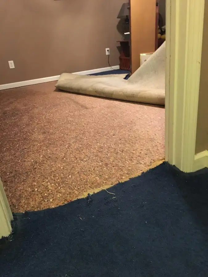 Carpet pad removal revealing water damage during Water Mitigation Services in San Leon